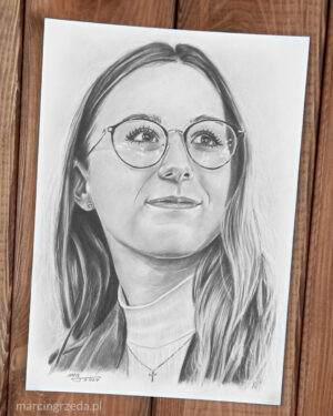 Portret czarnobiały wykonany ołówkiem na białym papierze przedstawiający uśmiechniętą kobietę w golfie i w okularach.