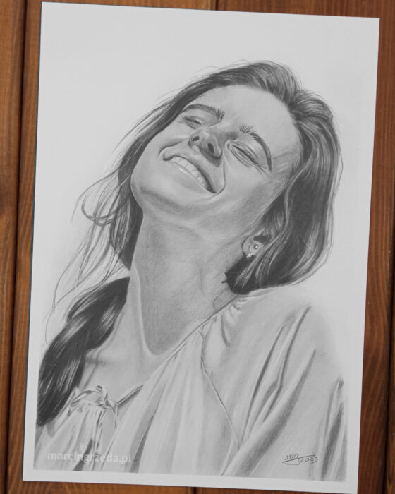 Portret narysowany ołówkiem przedstawiający młoda kobietę z twarzą zwróconą w kierunku słońca. Rysunek wykonany ba bloku Happy Color Rysunek.