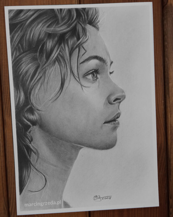 Portret dziewczyny wykadrowany z boku. NA portrecie widać tylko połowę twarzy. Rysunek wykonany ba bloku Happy Color Rysunek.