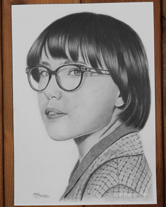 Rysunek ołówkiem przedstawiający dziewczynę z krótkimi czarnymi włosami. Portret z boku.