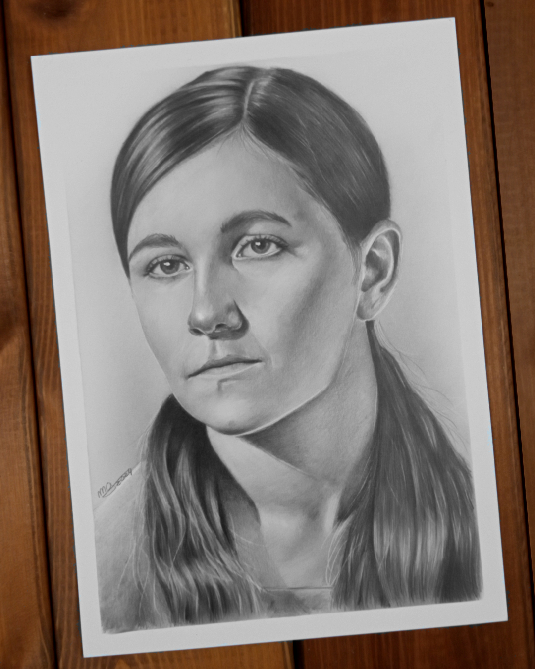 Portret ze starego zdjęcia legitymacyjnego wykonany ołówkiem na gładkim papierze. Rysunek przedstawia młodą dziewczynę.