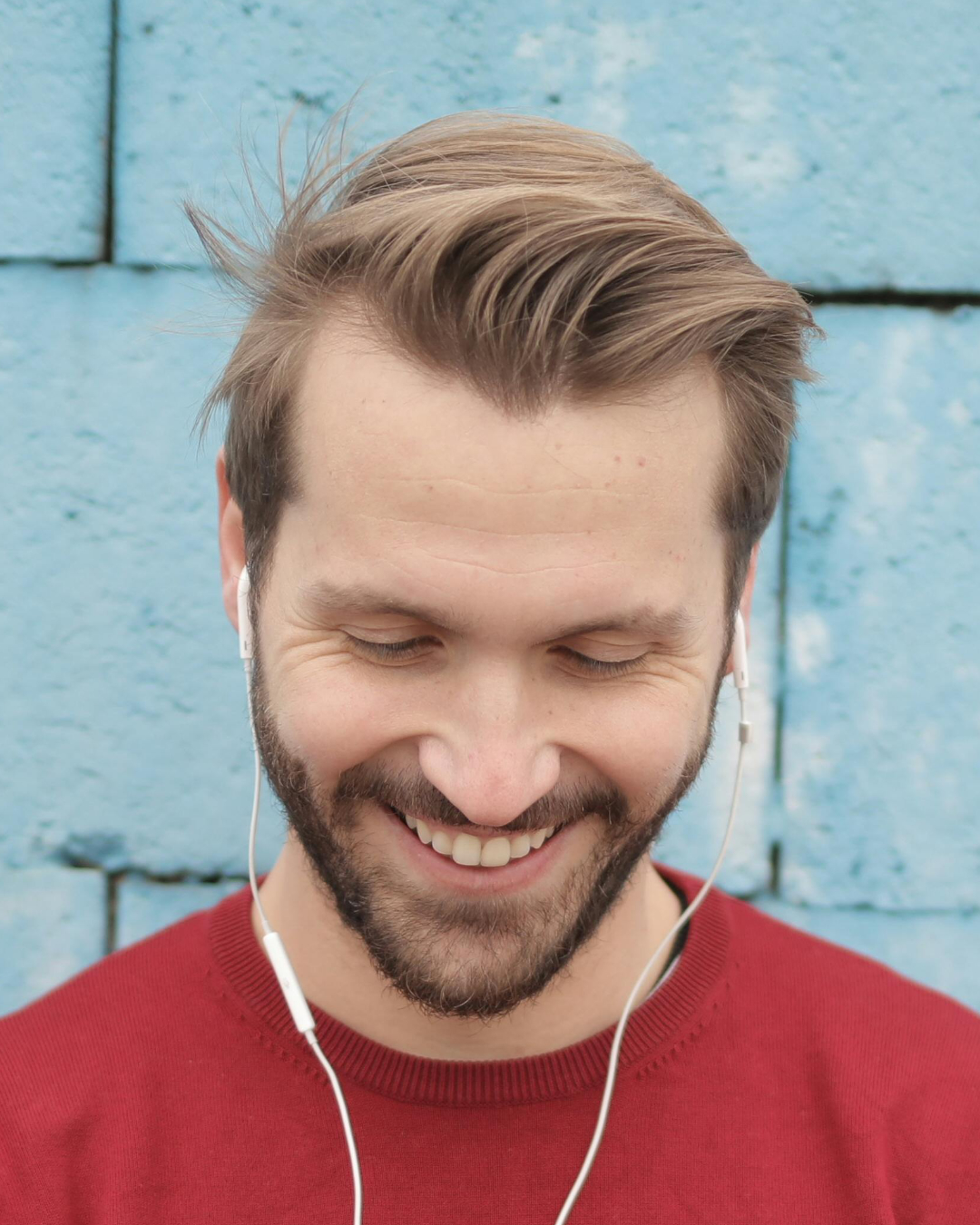 Zdjęcie przedstawia portret mężczyzny patrzącego na telefon. Widok jest z góry i nie widać oczu mężczyzny. Jest to przykład złego kadrowania, którego nie powinno sie wybierać do narysowania portretu ołówkiem ze zdjęcia.