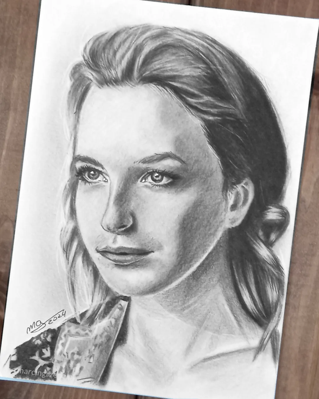 Ołówkowy portret kobiety widocznej nieco z profilu. 