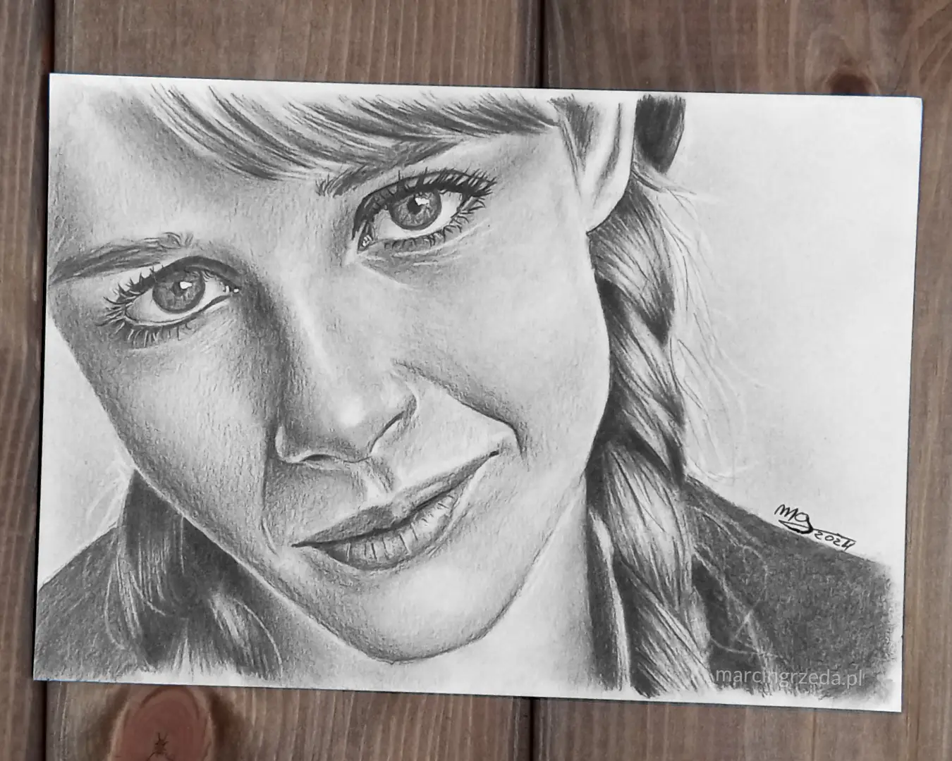 Ołówkowy portret dziewczyny z warkoczami wykonany na formacie A5, który ty również możesz zamówić ze swojego własnego zdjęcia.