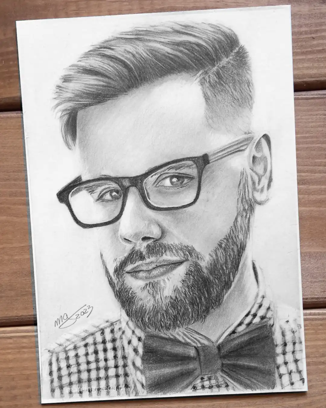 Portret chłopaka w okularach i w muszce ubranego w kraciastą koszulę wykonany ołówkiem na formacie A5. Format taki jest dostępny w mojej ofercie rysunków na zamówienie.
