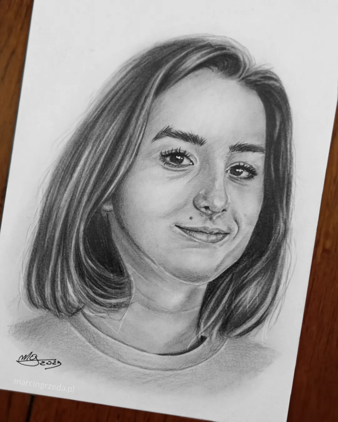 Portret kobiety z pieprzykiem i włosami sięgającymi za szyję. 