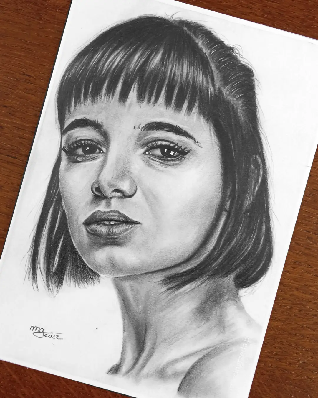 Ołówkowy portret pięknej kobiety z czarnymi włosami.