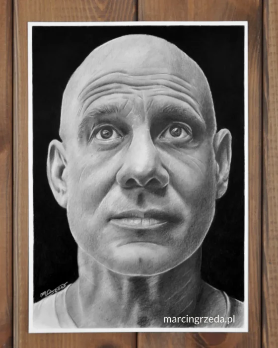 Rysunek ołówkiem na papierze formatu A4 wykonany ze zdjęcia. Portret przedstawia łysego mężczyznę patrzącego w górę. Tło portretu jest czarne również wykonane ołówkiem. Przykład portretu wykonywanego na zamówienie ze zdjęcia.