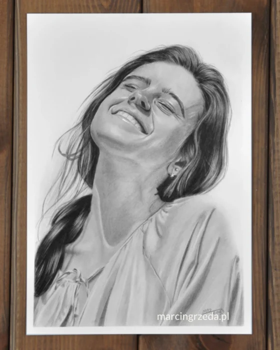 Portret wykonany ołówkiem. Na portrecie jest uśmiechnięta dziewczyna z warkoczem i przymkniętymi oczami w białej koszuli. Jest to przykład portretu na zamówienia w formacie A4 wykonany na białym papierze.