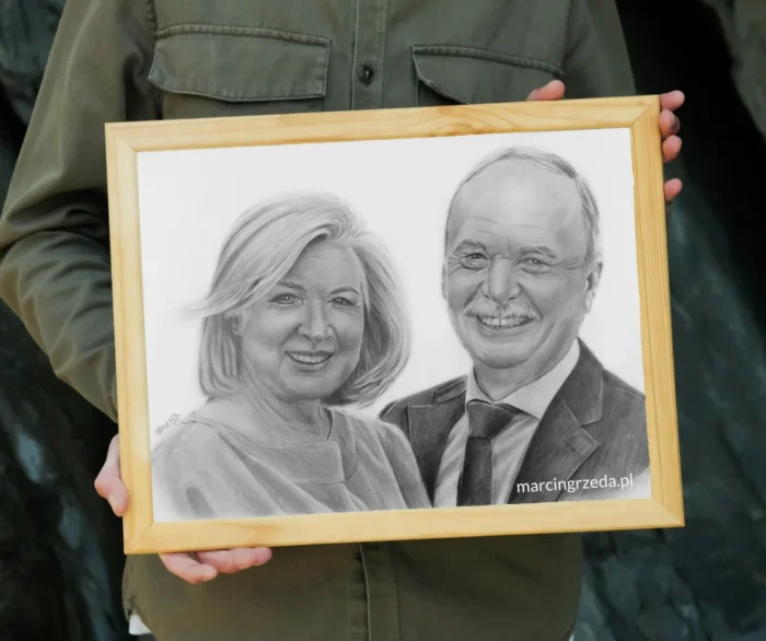 Zdjęcie przedstawiające chłopca trzymającego portret pary wykonany ołówkiem ze zdjęcia. Rysunek jest oprawiony w drewnianą ramkę. Jest to przykład prezentu na Walentynki.