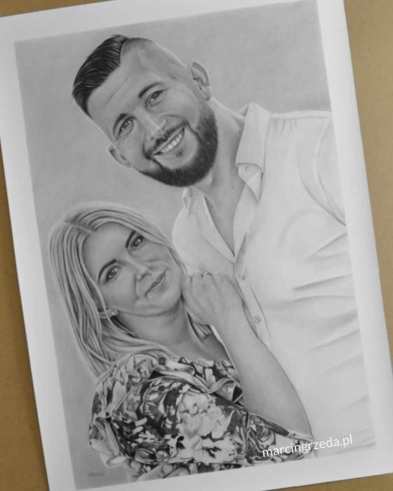Portret wykonany ze zdjęcia na zamówienie. Rysunek ołówkiem formatu 70x100 cm. Portret przedstawia parę. Kobieta jest w sukience w kwiaty natomiast mężczyzna w białej koszuli. Portret otoczony jest białą ramką co nadaje mu kontrastu.